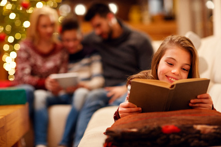 little girl lying and enjoying in good children book for Christmasの写真素材