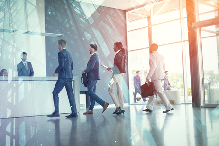 Business people arriving at reception deskの写真素材