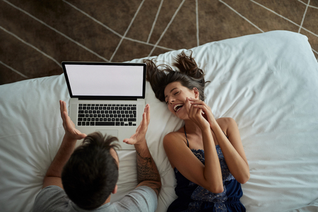 top view of Happy young couple with laptop in the bedの写真素材