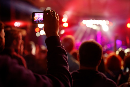 recording video with smartphone during a concert- summer music festival backgroundの写真素材