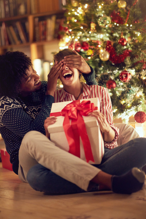 romantic surprise for Christmas â young male and female with presentの写真素材