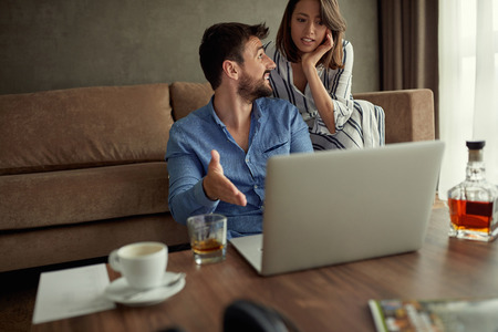 Couple enjoying time together browsing on laptop at homeの写真素材