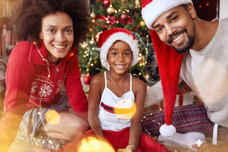 Portrait of smiling African American family in front of Christmas treeの写真素材
