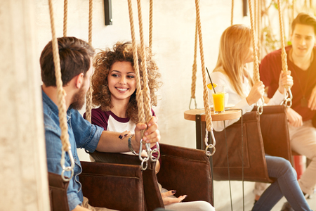 Young people chatting and enjoying on swingの写真素材