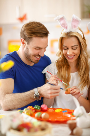 Male and female happy together painting eggs for Easterの写真素材