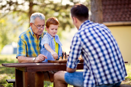 family having fun and playing chess at parkの写真素材