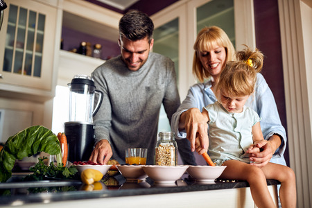 Mother with child and husband preparing healthy breakfastの写真素材