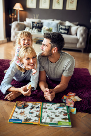 Daughter hugging mother at home while playingの写真素材