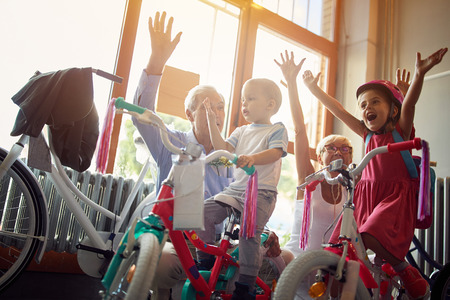 cheerful grandparents buying new bicycle for happy little grandchildren