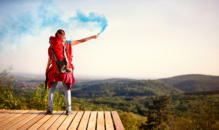 Young girl hiking and showing smoke signals torchの写真素材