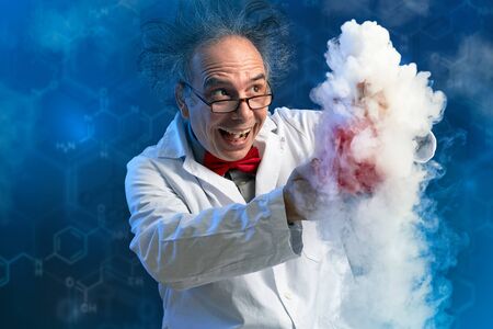 Happy crazy chemist with his experiment from which spews smoke