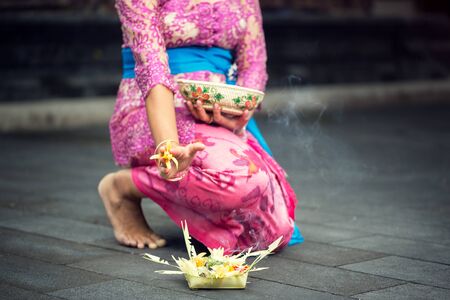 woman in traditional ceremonial clothing with offering for godsの写真素材