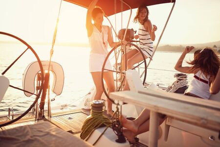 young beautiful people have fun on the yacht at sunset.の写真素材