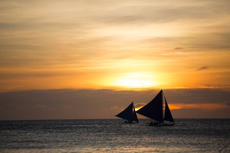 Beautiful fall sunset and sailboat in oceanの写真素材