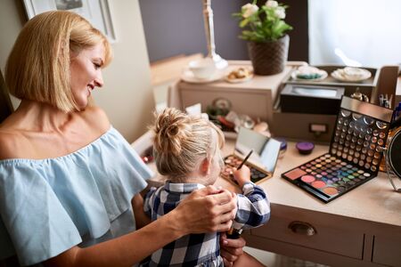 Female kid with mom is amusing with make upの写真素材