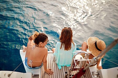 Group of young woman on the luxury boat together enjoy at summer dayの写真素材
