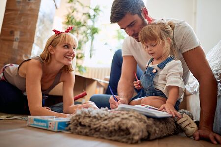 happy family playing in new house on the floorの写真素材