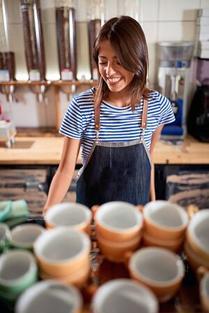 Smiling woman barista working in coffee shopの写真素材