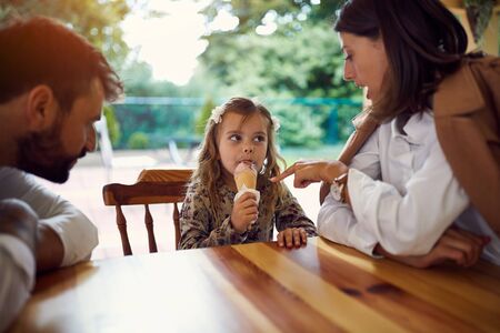 happy family eating icecream after school and workの写真素材