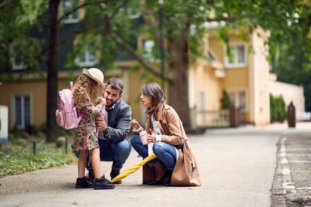 Young parents saying goodbye to their little child near schoolの写真素材