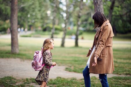 little schoolgirl runnig to her mother after first day of schoolの写真素材