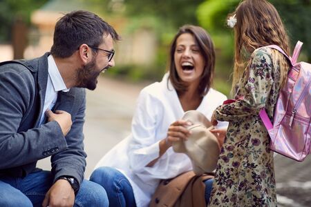 smiling parents with there daughter after school