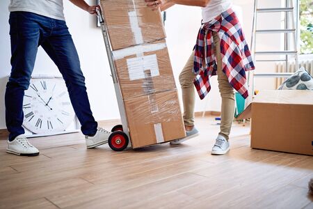 New home âYoung man and woman with cardboard boxes while moving in houseの写真素材