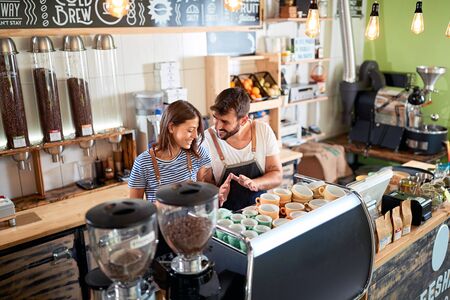 Smiling couple barista working in coffee shopの写真素材