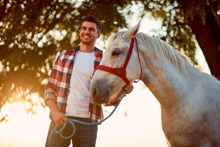 Young man and horse. Man have a hobby time, riding.の写真素材