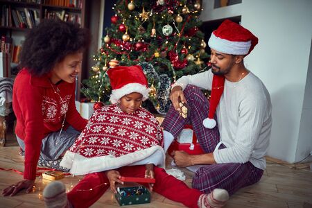 Happy parents with daughter in front of decorated Christmas tree at homeの写真素材