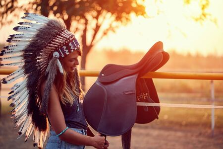 Smiling American Indian girl and horse at the sunset.