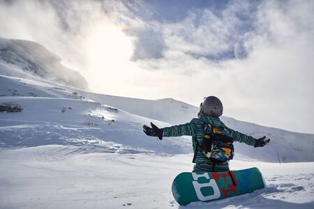 Happy Snowboarder with snowboard, winter holiday at the mountain