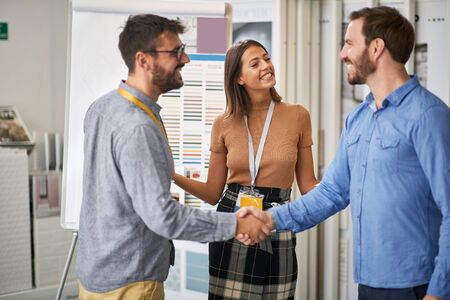 Young happy customer with salesman in store for household