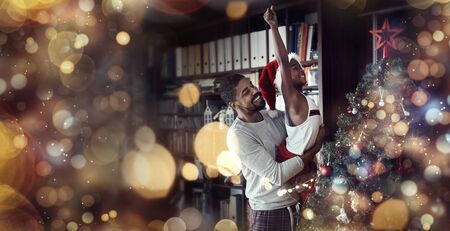 cheerful Father and happy daughter having fun together and putting ornaments on the Christmas tree