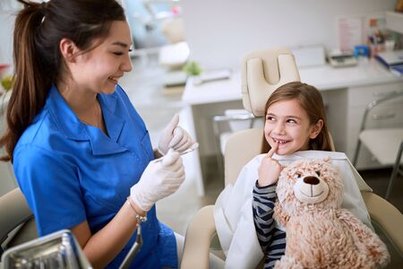Dental clinic.kid smiling girl sitts in the dentist's office.の写真素材
