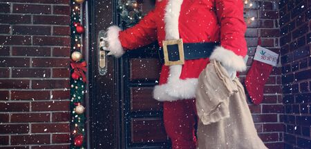Santa Claus opening door and arrive in homeの写真素材