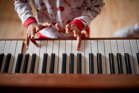 Girl hands playing music on piano.winter holidays and family conceptの写真素材