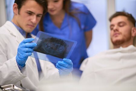 Dentist and his nurse observing an x-ray scan filmの写真素材