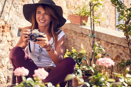 Cheerful smiling woman at vacation taking photosの写真素材