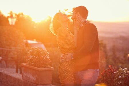 young man and woman hugging and kissing at the sunset の写真素材