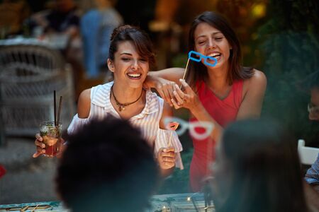 young adults talking and laughing in outdoor cafe. socializing, laughing, conversation concept