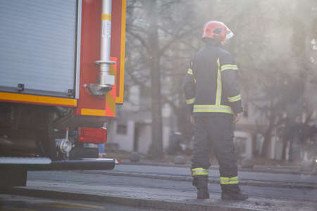 Fireman in uniform in front of fire truck going to rescue and protect. Emergancy , danger, servise concept.の写真素材
