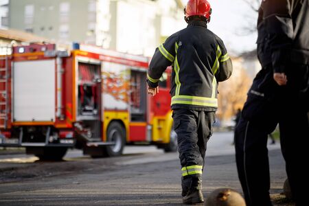 Fireman in uniform in front of fire truck going to rescue and protect. Emergancy , danger, servise...