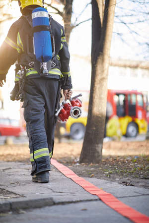Fireman in uniform in front of fire truck going to rescue and protect. Emergancy , danger, servise...