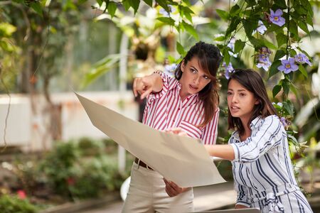 Smiling designer woman preparing to working exterior in garden. Plants.の写真素材