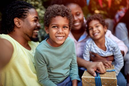 spontaneous horizontal portrait of young afro-american family with a little boy in focus....