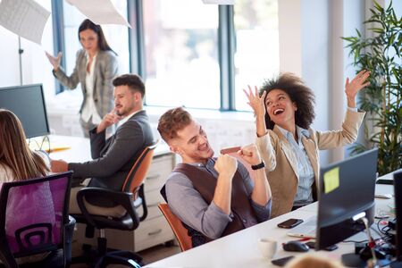 Office celebration, successful young woman, papers flying in the air, teamwork