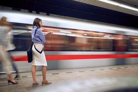 young businesswoman in subway looking at her wrist watch. Time goes by fast concept