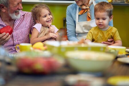 Grandparents and children spending happy time in the kitchen together.の写真素材