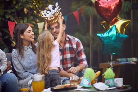 Little smiling girl having fun with her family at birthday party.の写真素材